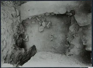 Field photograph of the cult deposit in K 7 at Idalion, with small vessels lying in situ in a rock-cut hollow.