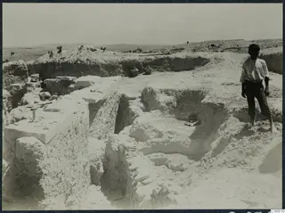 Excavation at the Acropolis of Idalion, with a young boy standing on the spoil beside the trenches