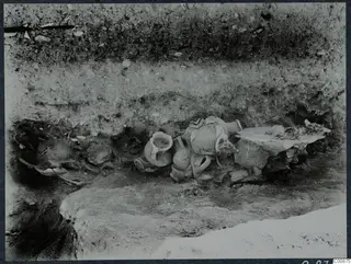 Pottery vessels lying in situ in excavated trench G 6-7 at Idalion, set against a layered soil section