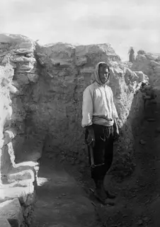 Osman with a pickaxe standing in an excavation trench at Idalion