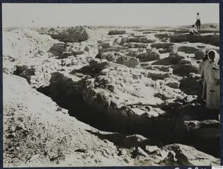 Excavation at Idalion Acropolis with exposed stone walls and people standing among the rubble