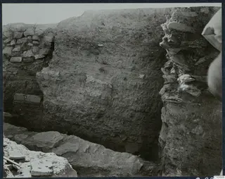 Excavation at Idalion Acropolis showing a trench with a tall earthen section and stone walling