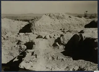 Excavated mound and cut stone walls on the Idalion acropolis, with hills in the distance