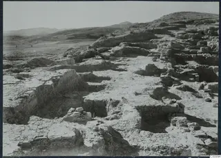 Excavated ruins with wall foundations and loose stone blocks on the Acropolis at Idalion