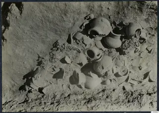 Pottery vessels and broken sherds lying in excavated soil at Idalion Acropolis
