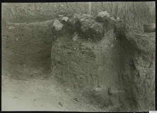 Excavated soil face at Plakes, Lapithos, with large stones lying on top of the earth bank
