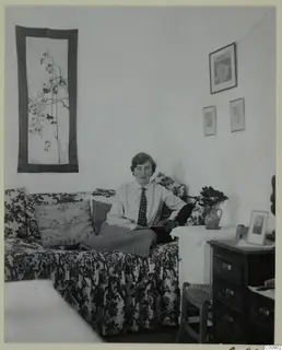 Vivi Gjerstad seated on a floral sofa in a room with wall hangings and framed pictures, Nicosia