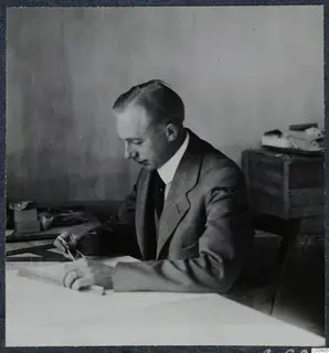John Lindros seated at a drawing board in Nicosia, working with a pencil and drawing instruments