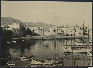 Harbour at Kyrenia with white buildings along the quay and small boats moored in the water
