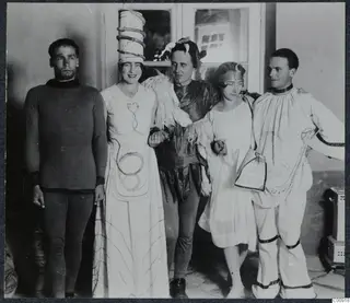 Five people in masquerade costumes posing together indoors in Nicosia.