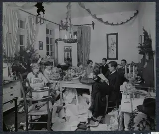 Family group in a decorated room with wrapping paper strewn on the floor after the Christmas presents are given out, Nicosia.