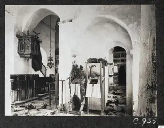 Interior of the monastery church, Lambousa, with a carved wooden pulpit and dark wooden benches