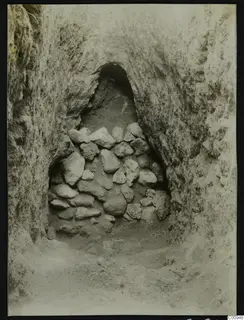 Tomb 417 at Lapithos during excavation, showing a burial chamber opening filled with stacked stones.