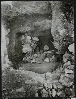 Excavated tomb chamber at Lapithos, its opening filled with heaped and stacked stones