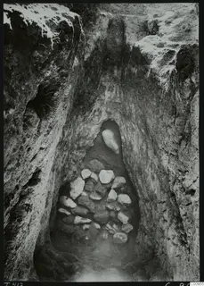 Tomb 417 at Lapithos Kastros: a sloping dromos cut into the ground, with a heap of stones at its far end.