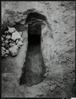 Tomb 426 at Lapithos Kastros: entrance to a tomb chamber through a sloping passage, with a pile of stones beside it