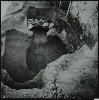 Excavated tomb 501 at Lapithos, a cut with stones piled along its upper edge and a chamber opening on the left.