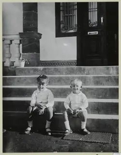 Martin and Stefan Gjerstad sitting on stone steps in front of a house door, Nicosia.