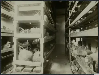 Storeroom with pottery vessels on wooden shelves and planks, Nicosia