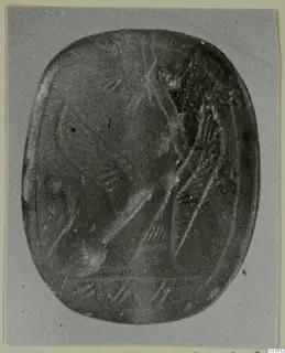 Engraved stone seal photographed face on, showing a pattern of incised lines and a curved form