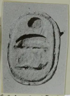 Scarab-shaped seal with a dark crescent mark near the top and horizontal lines across its base