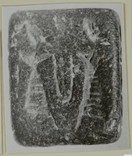 Rounded rectangular stone seal with a carved design of curved and upright strokes.