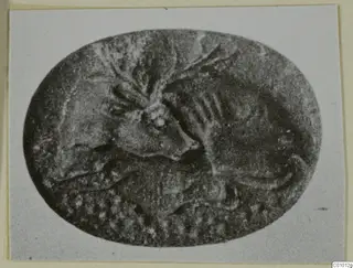 Oval engraved stone seal with a carved design of an animal figure and other motifs