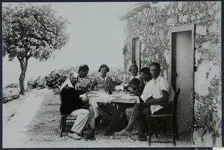 People at a breakfast table outside a stone building at Vouni