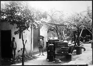 Snowy courtyard of the Swedish Institute in Nicosia, with two children standing by a whitewashed wall and stacked crates.