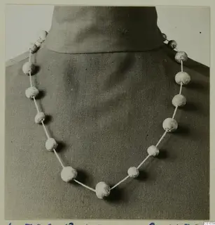 Necklace of pale faience beads strung on a cord, shown on a dressmaker's form at Lapithos.