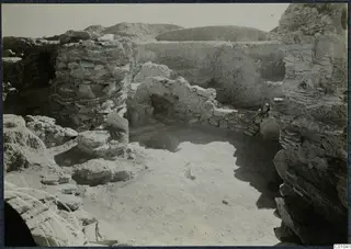 Excavated area on the Idalion acropolis with stone walls and rubble around an open floor