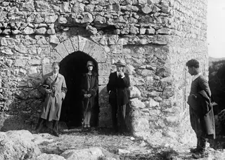 Four people posing beside an arched doorway in a rounded stone tower at St. Hilarion