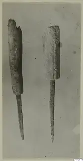 Two corroded metal awls with thick cylindrical upper parts and long pointed shanks, from the Vrysi tou Barba tombs at Lapithos