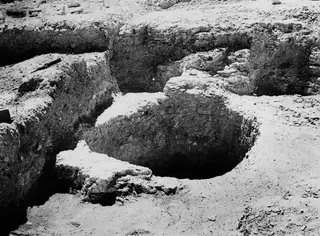 Excavated well shaft at Idalion, seen from above with cut earth banks and a stone-lined rim.