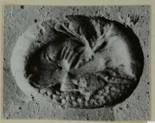 Impression of a cylinder or stamp seal showing a figure and marks, in grey tones.