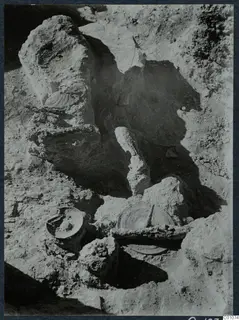 Excavation at Idalion Acropolis with large stones and objects lying in the dug soil.