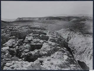 Excavated stone walls and rubble on the Idalion acropolis, with rolling hills beyond.