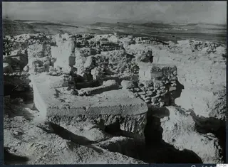 Excavated stone walls and foundations on the Acropolis at Idalion, with hills and a wide valley beyond.