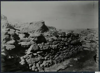 Excavated stone wall with large slabs and rubble at Idalion Acropolis, with an eroded earthen mass behind