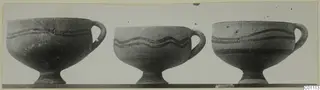 Three White Painted I bowls on pedestal bases, standing side by side with dark painted bands around their bodies
