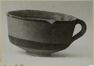 Pottery White Painted III-1 bowl with a single loop handle and a dark band around the lower body