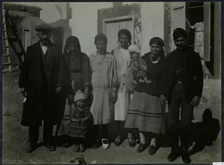 Group photograph of the Neofytou family standing outside a whitewashed house at Milia