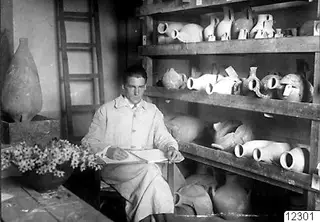 Alfred Westholm seated before shelves of pottery jars at the Swedish Institute in Nicosia