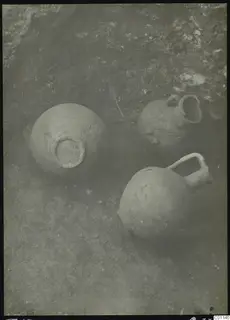 Three clay vessels lying in the soil during excavation of Tomb 13 at Marion