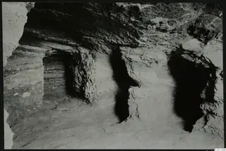 Interior of Tomb 2 at Marion during excavation, showing rock-cut walls and a loose soil floor