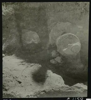 Tomb 6 at Marion during excavation, with a large round vessel and loose stones in the cut
