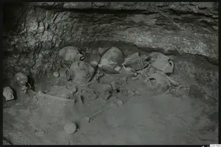 Tomb 10 at Marion with a cluster of pottery vessels and skeletal remains on the tomb floor
