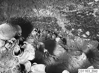 Interior of Tomb 5 at Marion with pottery vessels lying on the floor of the chamber