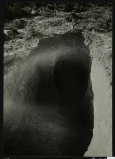 Excavation at Tomb 12 at Marion, showing the sloping dromos leading down to the dark tomb entrance.