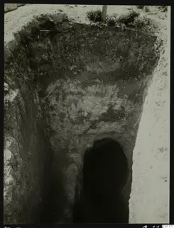 Tomb 5 at Marion during excavation, looking down a sloping dromos to the dark arched tomb entrance